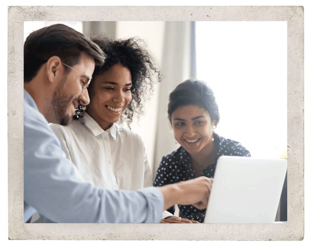 A smiling group looking a laptop screen